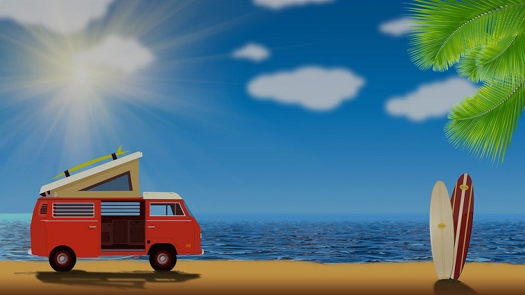 Obrazek przedstawia samochód kempingowy stojacy na plaży a obok niego stojące dwie deski sufringowe